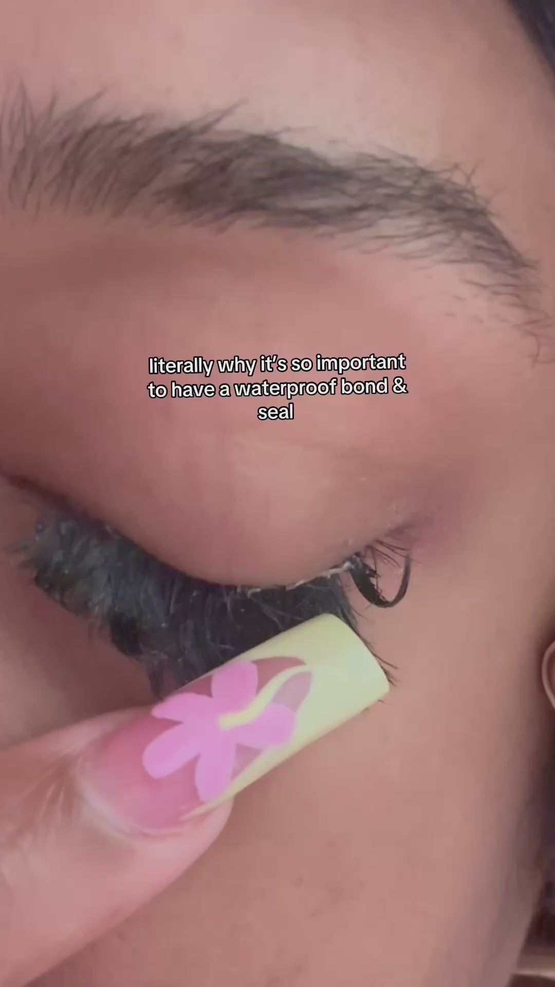 Load video: Girl is demonstrating the effectiveness of lash glue by pouring water on her cluster lash set, and tugging at the clusters repeatedly